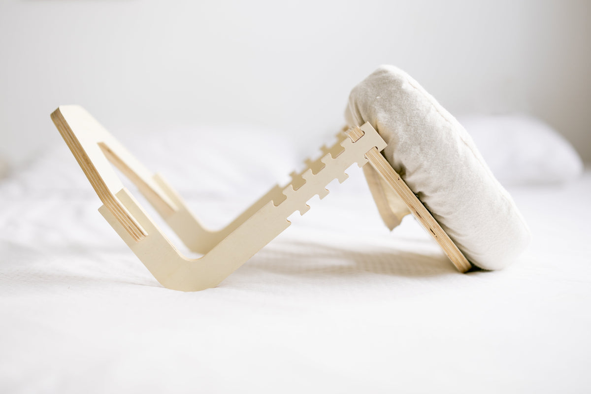 El marco de madera desplegado sobre una cama blanca
